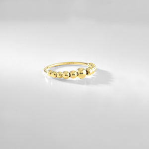 The 14k Gold Bubble Ring features a series of polished, spherical beads, resulting in a delicate and elegant design. This handcrafted piece boasts a smooth finish with a simple yet stylish look, beautifully highlighted against a plain white background to emphasize its genuine allure.