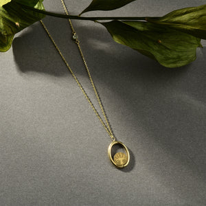 Introducing the 14K Real Gold Tree of Life Necklace: This exquisite piece showcases a delicate chain adorned with an oval-shaped pendant. Within the pendant lies a beautifully textured gold design, echoing the timeless Tree of Life motif. A small lab-created diamond accent graces one side of the chain, elegantly set against a simple white background.