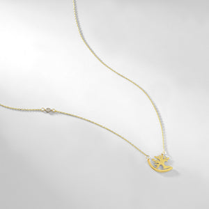 A delicate 14k Gold Tree of Life Necklace showcases a pendant shaped like a reindeer, adorned with two small crystals on its elegant chain. The stylized reindeer features a curved body and intricate antlers, while the thin chain enhances its timeless charm.