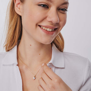 The 14K Solid Gold Cubic Zirconia Solitaire Necklace showcases a heart-shaped design with a stunning cubic zirconia gemstone, elegantly suspended from a delicate chain against a white background.