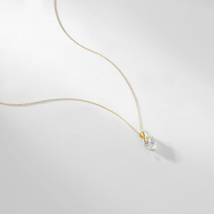 The 14K Solid Gold Cubic Zirconia Solitaire Necklace showcases a heart-shaped design with a stunning cubic zirconia gemstone, elegantly suspended from a delicate chain against a white background.