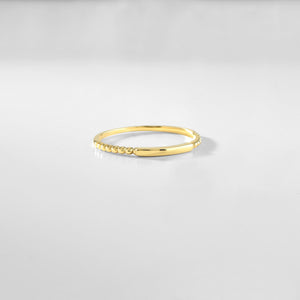 Introducing the 14K Solid Gold Minimalist Stacking Ring, a simple and elegant piece featuring a smooth, thin band with sides adorned in small, round bead-like designs. Its polished surface makes it ideal for sophisticated style and those who appreciate dainty elegance.