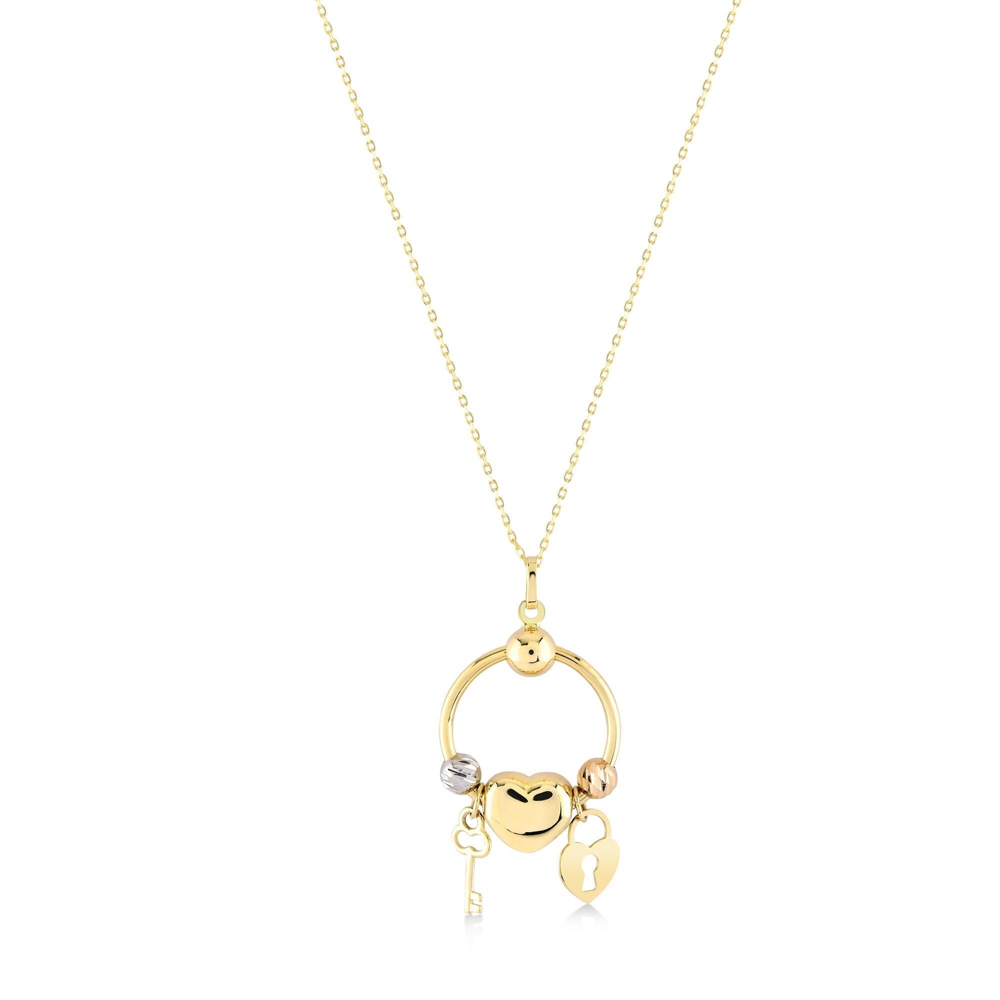 The 14K Solid Gold Heart Lock Key Necklace by RundaJewelryUs features a circular pendant adorned with three charms: a silver key, a gold heart, and a gold padlock with a keyhole. This pendant gracefully hangs from an elegant, delicate gold chain, capturing the timeless beauty of the lock and key design.