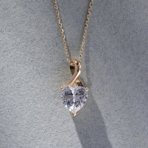 The 14K Solid Gold Cubic Zirconia Solitaire Necklace showcases a heart-shaped design with a stunning cubic zirconia gemstone, elegantly suspended from a delicate chain against a white background.