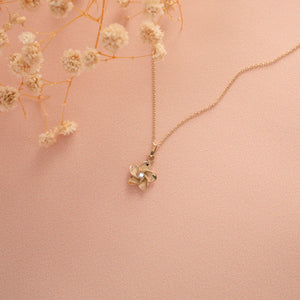 Experience the exquisite charm of the 14K Gold Plumeria Necklace by RundaJewelryUs. This captivating piece showcases a real solid gold flower-shaped pendant with five petals, accented by a delicate diamond at its center, all gracefully suspended from a refined gold chain. Ideal as a Summer Jewelry Gift for Her, this necklace effortlessly blends elegance with timeless allure.