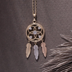 Introducing the 14K Gold Dreamcatcher Necklace by RundaJewelryUs, crafted from real 14K gold and featuring a beautiful flower design adorned with small gems. Three feather-shaped charms in gold, silver, and bronze dangle elegantly beneath. This hypoallergenic piece is ideal for those with sensitive skin.