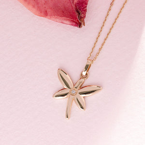 The 14K Gold Dragonfly Necklace boasts a 14K Gold mini dragonfly pendant embellished with a small, round white gemstone at its center. Its graceful chain elegantly connects to the top of the pendant, displayed on a plain white background for an everlasting allure.