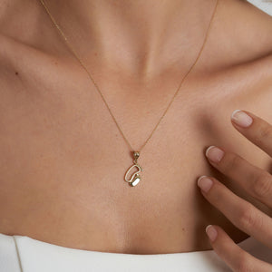 This exquisite piece, the 14K Solid Gold New Baby Feet Necklace by RundaJewelryUs, showcases a pendant in the shape of two baby footprints. It's an ideal choice for new moms, with one footprint featuring a small diamond. The pendant elegantly dangles from a delicate chain.