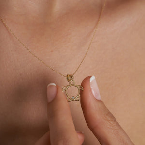 The 14K Gold Sea Turtle / Caretta Caretta Necklace from RundaJewelryUs features a gold turtle pendant with a diamond accent at the bottom center, elegantly hanging from a delicate gold chain against a white background. This exquisite piece of jewelry symbolizes good luck and adds ocean-inspired charm to any ensemble.