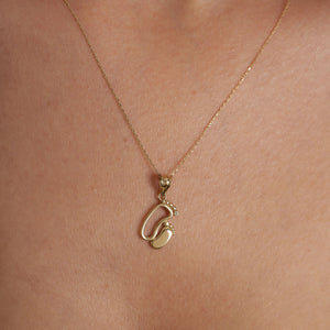 This exquisite piece, the 14K Solid Gold New Baby Feet Necklace by RundaJewelryUs, showcases a pendant in the shape of two baby footprints. It's an ideal choice for new moms, with one footprint featuring a small diamond. The pendant elegantly dangles from a delicate chain.