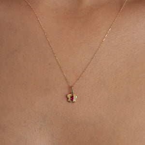 Presenting the 14K Gold Tiny Ruby Butterfly Necklace, this piece features a marquise-cut pink gemstone at the center of its butterfly-shaped pendant. The necklace boasts a delicate chain that completes its graceful design, exemplifying sustainable jewelry craftsmanship against a plain white backdrop.