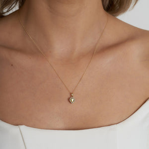 Introducing the 14K Gold Heart Shaped Citrine Necklace for women, featuring a central yellow citrine gemstone beautifully encircled by a halo of petite white diamonds, elegantly set against a simple light backdrop.