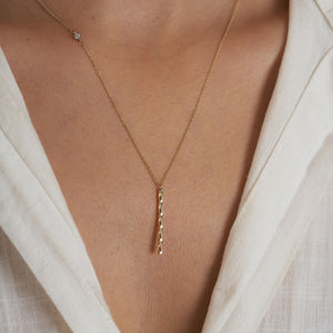 The RundaJewelryUs 14K Gold Twisted Vertical Bar Diamond Necklace highlights a delicate solid gold chain featuring a small, genuine diamond pendant on one side, paired with a textured vertical gold bar pendant that gracefully hangs in the center against a plain white background.