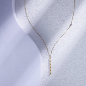 The RundaJewelryUs 14K Gold Twisted Vertical Bar Diamond Necklace highlights a delicate solid gold chain featuring a small, genuine diamond pendant on one side, paired with a textured vertical gold bar pendant that gracefully hangs in the center against a plain white background.