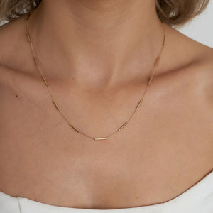 The 14K Gold Station Minimal Chain Necklace features small, evenly spaced bar links arranged in a circular shape against a plain white background, making it ideal for layering or wearing alone as a standout solid gold chain piece.