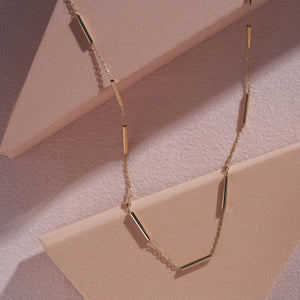 The 14K Gold Station Minimal Chain Necklace features small, evenly spaced bar links arranged in a circular shape against a plain white background, making it ideal for layering or wearing alone as a standout solid gold chain piece.