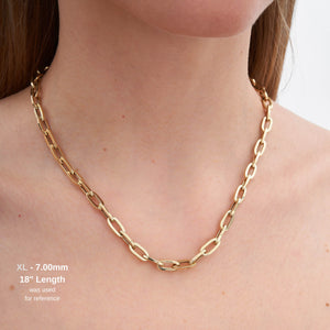 A collection of gold chains, highlighted by the exquisite 14K Gold Paperclip Chain Necklace, is arranged in a semi-circle. Each piece showcases distinct link sizes and styles characteristic of Italian design jewelry. They are layered from smallest to largest, creating a cascading effect against the white background.