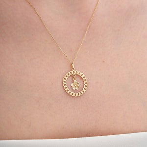 The 14K Gold Plumeria Wreath Pendant Necklace features a circular chain-link design and is adorned with a delicate flower charm at the center.