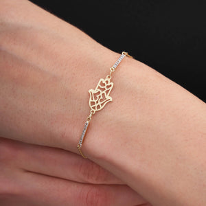 The 14K Gold Hamsa Hand Charm Protection Bracelet is an exquisite piece, featuring a lattice-detailed hamsa hand charm surrounded by small, sparkling gemstones on a delicate chain. This elegant Good Luck Kabbalah Jewelry piece offers both protection and sophistication, secured with a lobster clasp closure.