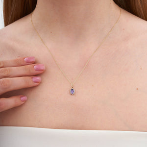 Product Description: The 14K Gold Amethyst Necklace features an oval-shaped amethyst pendant encircled by a halo of shimmering zirconia stones. Its elegant design is mesmerizing, set against a pure white backdrop.