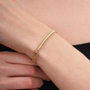 A 14K gold handmade bracelet from RundaJewelryUs, featuring a snake design and a lobster clasp, is elegantly laid flat on a white background.