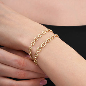 The 14K Solid Gold Mariner Anchor Chain Bracelet features a lobster clasp, making it perfect for layering and adding elegance to any outfit.