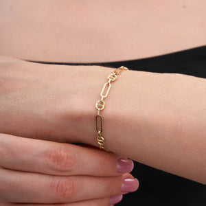 Introducing the 14K Gold Paperclip Mariner Link Chain Bracelet: This stunning piece features alternating elongated oval and circular chain links, ideal for layering. Crafted from 14K solid gold, it includes a lobster clasp and an adjustable chain segment for a customizable fit.