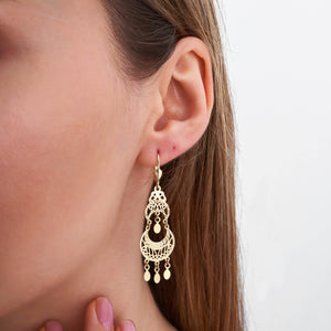 The 14K Real Gold Dream Catcher Earrings are showcased on a white background, boasting elaborate cutout designs with crescent shapes and dangling round elements. These lightweight, hypoallergenic earrings are ideal for sensitive skin.