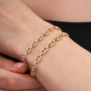 The 14K Solid Gold Mariner Anchor Chain Bracelet features a lobster clasp, making it perfect for layering and adding elegance to any outfit.