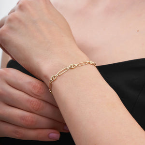 Introducing the 14K Gold Paperclip Mariner Link Chain Bracelet: This stunning piece features alternating elongated oval and circular chain links, ideal for layering. Crafted from 14K solid gold, it includes a lobster clasp and an adjustable chain segment for a customizable fit.