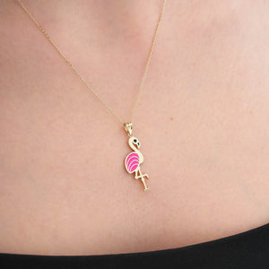 Presenting the 14K Gold Flamingo Necklace, a delightful piece that showcases a flamingo pendant intricately adorned with pink and red enamel for a vibrant appearance. This charming jewelry item is elegantly suspended on a dainty gold link chain, all set against a simple white backdrop.