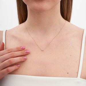 The 14K Gold Trio Necklace is a delicate piece with three small, round diamond stones set in a row on a thin, hypoallergenic gold chain against a light background.