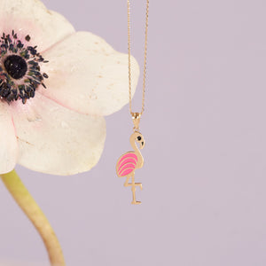 Presenting the 14K Gold Flamingo Necklace, a delightful piece that showcases a flamingo pendant intricately adorned with pink and red enamel for a vibrant appearance. This charming jewelry item is elegantly suspended on a dainty gold link chain, all set against a simple white backdrop.