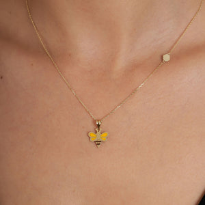 Introducing the Minimal Tiny 14K Real Gold Bee Necklace, featuring a gold chain adorned with a handcrafted bee pendant. Made from 14K solid gold, this exquisite bee design showcases striking black stripes and vibrant yellow wings for an eye-catching look.