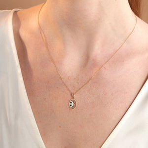 Experience the charm of the 14K Gold Lover Panda Necklace, showcasing a pendant with an adorable panda face in vibrant black, white, and gold tones. A petite red heart embellishes its cheek, gracefully hanging from an elegant gold link chain. The perfect accessory for fans of Cute Animal Jewelry, set against a simple white backdrop.