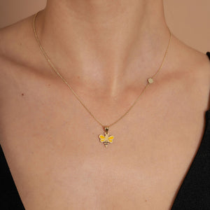 Introducing the Minimal Tiny 14K Real Gold Bee Necklace, featuring a gold chain adorned with a handcrafted bee pendant. Made from 14K solid gold, this exquisite bee design showcases striking black stripes and vibrant yellow wings for an eye-catching look.