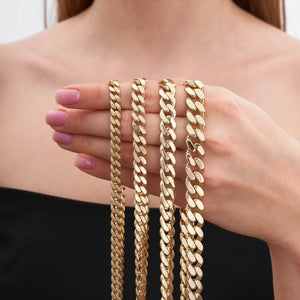 A close-up of the 14K Gold Miami Cuban Curb Link Chain Bracelet by RundaJewelryUs, meticulously crafted with interlocking links and finished in genuine 14K gold. It features a sleek clasp at one end and a box clasp at the other, elegantly displayed against a plain white background.