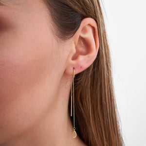 The 14K Yellow Gold Long Threader Earrings with Leaves by RundaJewelryUs feature a delicate chain and leaf-shaped charms at the ends, showcased against a white background.