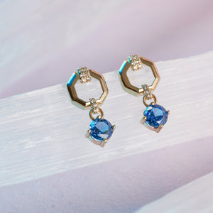 14K Real Gold London Blue Topaz Earrings feature hexagonal loops embellished with small white gemstones and dangling round-set London Blue Topaz.