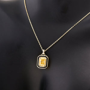 The 14K Gold Citrine Necklace showcases a rectangular yellow gemstone pendant, elegantly framed in black and adorned with small white stones. Its delicate chain enhances the vibrant centerpiece perfectly.