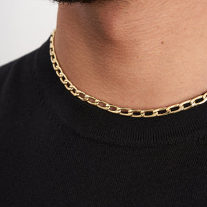 The 14K Real Gold Cuban Curb Link Chain Necklace, featuring elongated links, is showcased against a plain white background. It forms a U shape, emphasizing its simple yet elegant design—ideal for both men and women.