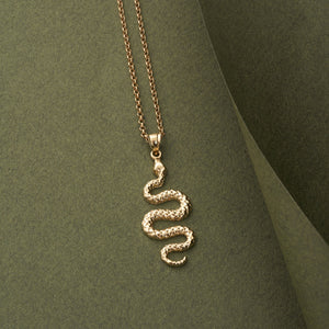 This 14K Solid Gold Serpent Pendant Necklace features an intricately designed snake pendant in an S-shape with a textured finish, elegantly suspended from a fine chain. It's an ideal piece of animal-themed jewelry for those who admire distinctive artistry.