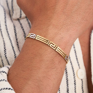 This 14K Solid Gold Greek Key Bracelet for Men features a geometric pattern with alternating rectangular links. The design combines both smooth and textured surfaces, complete with a clasp on one end, set against a plain white background.