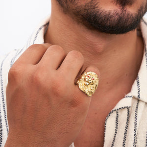 This 14K real solid gold lion ring for men features an intricate lion’s head design with striking red gemstone eyes against a plain white backdrop. The exquisitely detailed mane flows elegantly around the sides, making it a standout piece of animal jewelry for men.