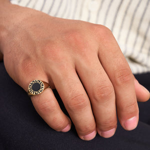 Discover the 14K Solid Gold Black Enamel Greek Key Ring for Men, a modern and sleek piece featuring a black circular face adorned with an intricate labyrinth meander pattern around the edge. This contemporary design adds a fresh twist to the classic signet ring style.