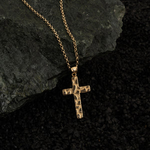 The 14K Solid Gold Nugget Texture Cross Necklace for Men showcases a textured design on a solid gold cross, exemplifying Christian jewelry elegance as it hangs from a delicate chain against a plain white background.