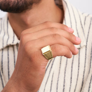 Discover the perfect men's jewelry statement piece: the 14K Solid Gold Watch Style Fancy Signet Ring for Men. This ring showcases a stunning engraved signet with a large rectangular top and ribbed band design, set against a white background.