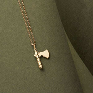 The 14K Solid Gold Axe Pendant Necklace for Men showcases a captivating axe pendant, complete with a textured handle and smooth blade, elegantly hanging from a gold chain.