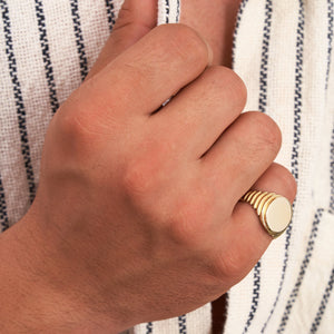 The 14K Solid Gold Watch Style Fancy Signet Ring for Men features a sleek, round, smooth top and a ribbed design on the sides, adding a contemporary and elegant touch. Ideal for men's jewelry aficionados, this engraved signet ring is set against a plain white background, allowing its polished finish to truly shine.