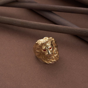 This 14K real solid gold lion ring for men features an intricate lion’s head design with striking red gemstone eyes against a plain white backdrop. The exquisitely detailed mane flows elegantly around the sides, making it a standout piece of animal jewelry for men.